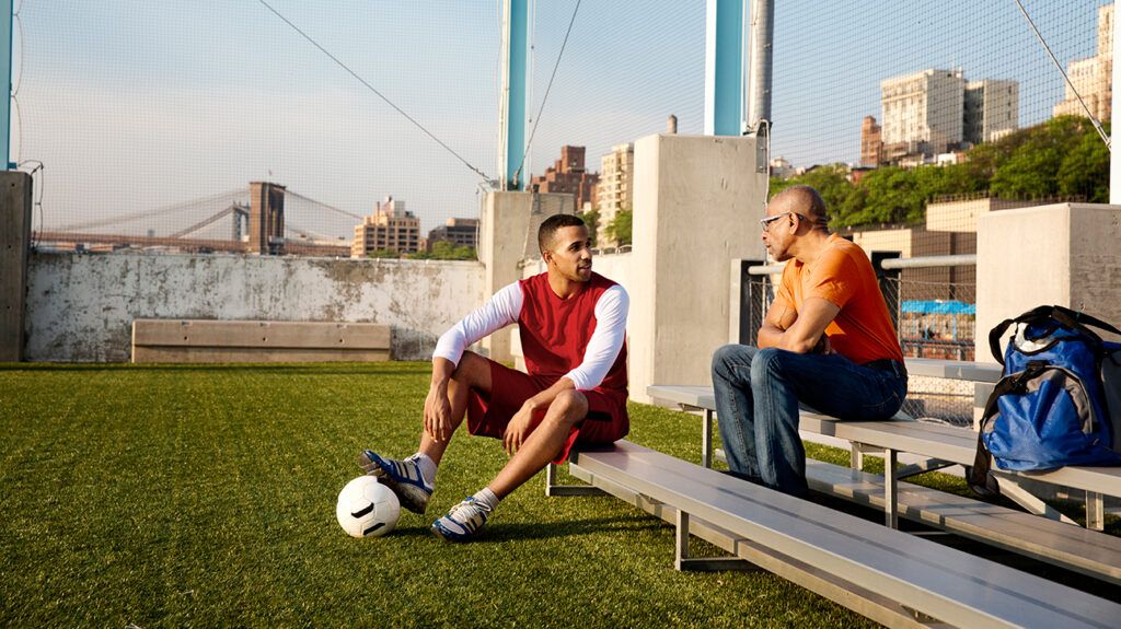 Father and son on soccer field bleachers