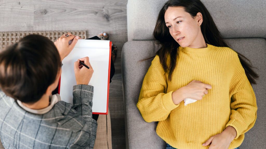 a woman on a couch talking to a therapist